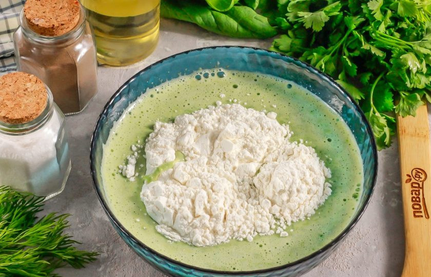 1. Этап. Блинчики шпинатные: Просейте пшеничную муку высшего сорта и аккуратно вмешайте ее в массу, добавляя по частям. Лучше всего использовать венчик и не взбивать, а вмешивать муку, чтобы не образовались комочки. Как только это сделаете, влейте в тесто растительное масло и снова перемешайте. Оставьте тесто в покое на 10 минут, чтобы активизировалась клейковина.