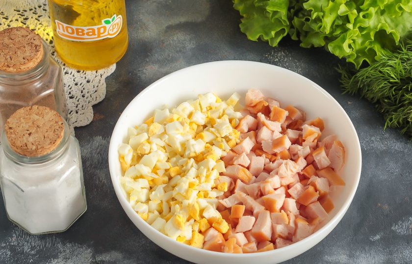 1. Этап. Круассаны с куриным салатом внутри: Очистите отварное куриное яйцо от скорлупы и промойте в воде. Нарежьте мелким кубиком. Точно так же нарежьте и копченое куриное филе. Выложите нарезки в глубокую емкость.