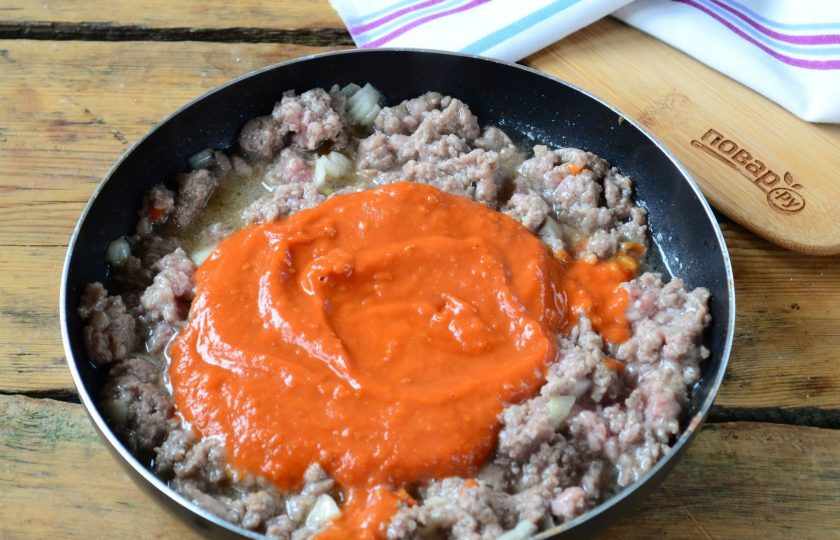 1. Этап. Пирог из спагетти под сыром: Добавьте в сковороду томатный соус, перемешайте, убавьте огонь и готовьте 5-7 минут.