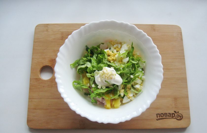 1. Этап. Салат с ананасом на Новый год: Заправьте салат сметаной и майонезом, добавьте измельченный чеснок.