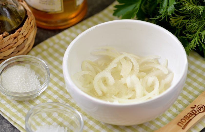 1. Этап. Салат из свеклы с маринованным луком: Небольшую луковицу нарежьте полукольцами, переложите ее в небольшую пиалу, влейте уксус, теплую воду, всыпьте неполную чайную ложку сахара. Перемешайте лук в маринаде, оставьте минут на 10.