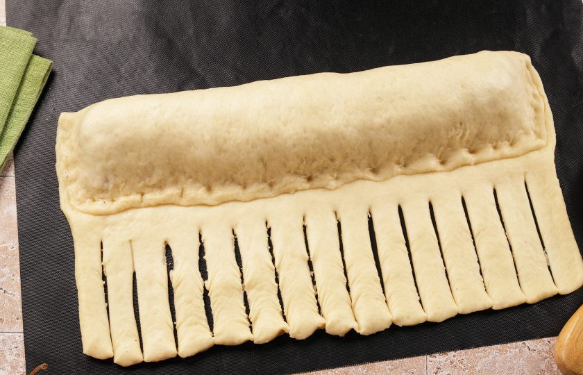 1. Этап. Пирог на дрожжах с яблоками: Накройте начинку тестом и защипните края. Оставшуюся часть теста нарежьте на полоски шириной 1-1,5 см.