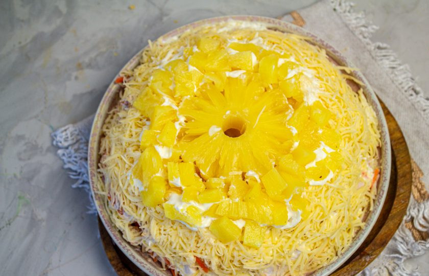 1. Этап. Салат Ананасовое кольцо: Оставшиеся ананасы нарежьте мелкими кубиками и украсьте салат сверху. Салат уберите в холодильник для стабилизации на несколько часов.