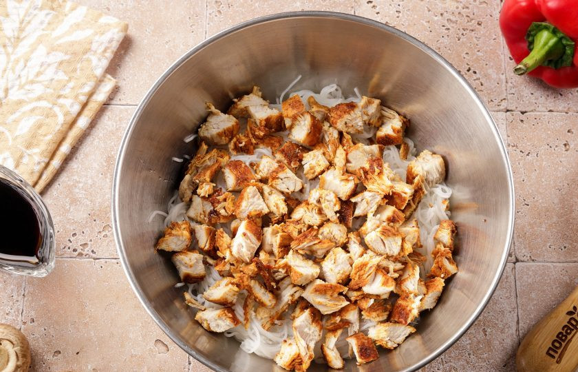 1. Этап. Фунчоза с курицей и шампиньонами: Остывшее куриное филе нарежьте кубиками и добавьте к фунчозе.