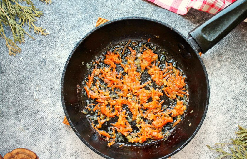 1. Этап. Кукурузная каша с тушенкой: Чеснок мелко порежьте, выложите в сковороду и обжаривайте еще одну минуту.