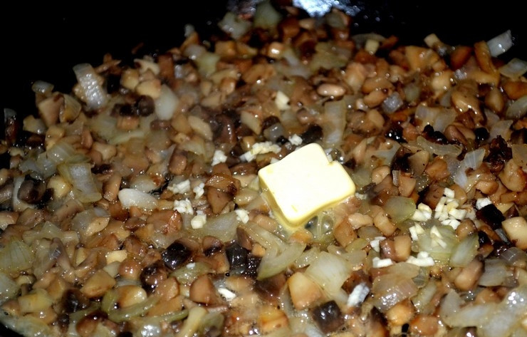 1. Этап. Вешенки с сыром: К луку добавьте грибы, в сковороду налейте несколько столовых ложек чистой воды. Протушите ингредиенты, пока не выпарится жидкость. Затем добавьте немного сливочного масла, раздавленный зубчик чеснока и дождитесь, когда на грибах появится золотистая корочка.