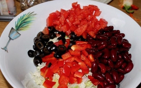 1. Этап. Салат с фасолью красной: В миску выкладываем консервированную фасоль, нарезанную соломкой капусту. Перец и помидор нарежем кубиками, оливки нарежем кружочками.
