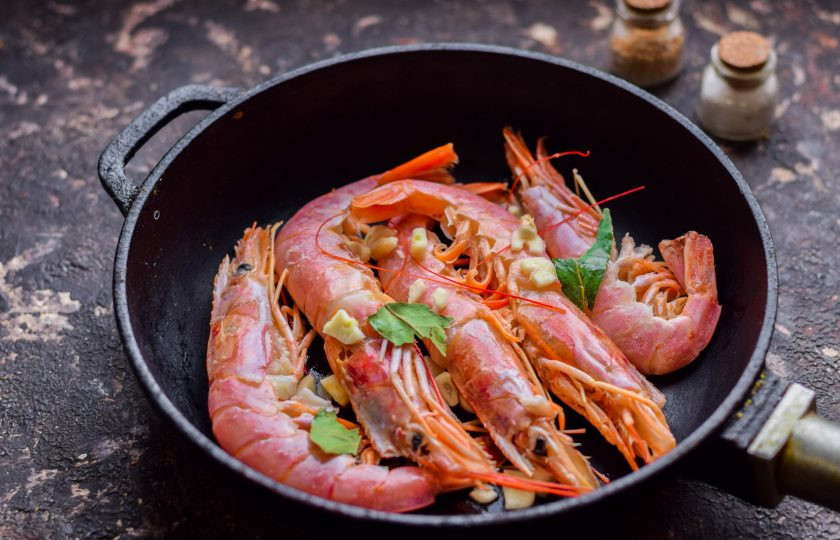 1. Этап. Лангустины в соусе Терияки: Подготовьте сковороду, переложите лангустины. Добавьте в сковороду нарезанный чеснок и поломанный лавровый лист.