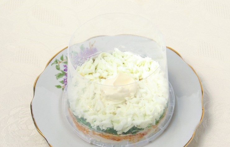 1. Этап. Салат Мимоза (рецепт с рисом): В кастрюльке отварите яйца в крутую (в течение десяти минут). Остудите их и очистите от скорлупы. Затем отделите белки от желтков и натрите их на терке. Выложите слой белков в кольцо и смажьте майонезом.