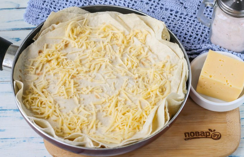 1. Этап. Пирог из лаваша на сковороде: Накройте творог обрезками лавашей, снова присыпьте сыром. Повторяйте слои, пока они не закончатся, но помните, что последний слой должен быть с сыром, чтобы пирог получился красочным и аппетитным на вид.