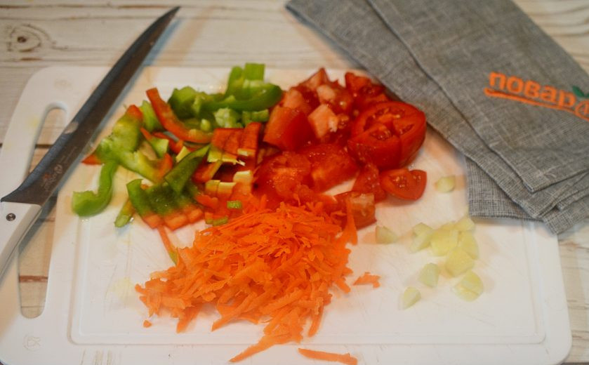 1. Этап. Говядина по-цыгански: 5. Все овощи почистите и удалите семена. Нарежьте помидоры кубиком, чеснок -произвольно, перец - соломкой, а морковь натрите на терке.