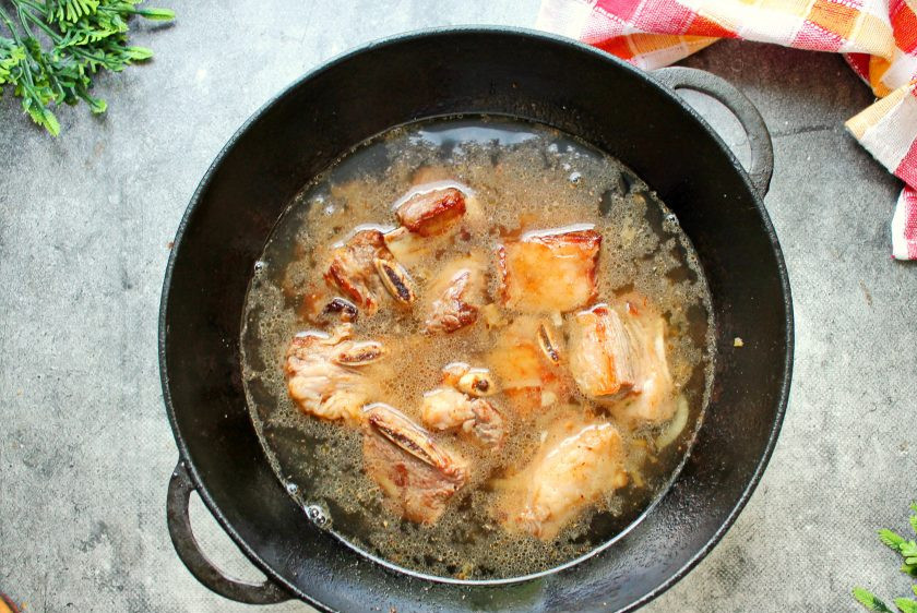 1. Этап. Говяжьи ребрышки в казане с луком: Влейте горячую воду.