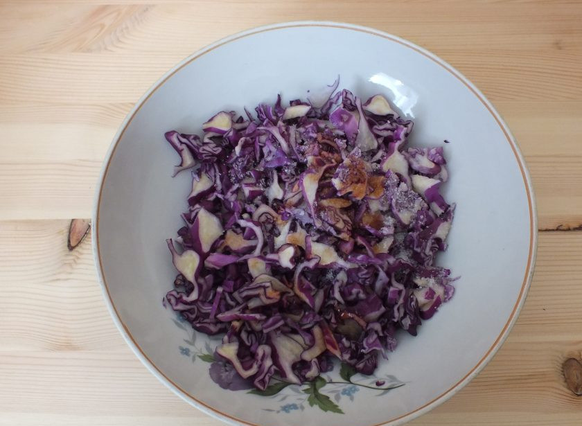 1. Этап. Салат с красной капустой и помидорами: Нарежьте капусту тонкой соломкой. Переложите в салатник. Сбрызните уксусом, добавьте соль, сахар и черный перец. Хорошо помните руками, пока не появится сок. Оставьте на 15 минут при комнатной температуре.