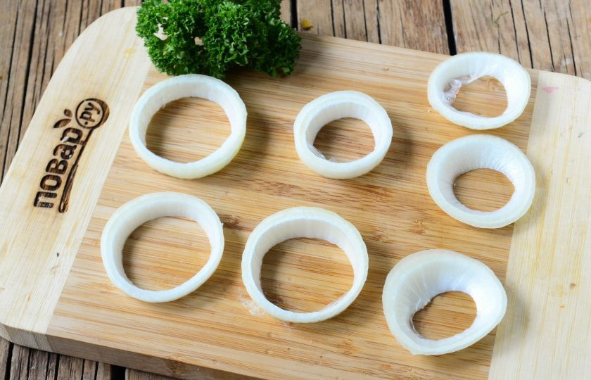 1. Этап. Луковые кольца в беконе и панировке: Лук очистите от шелухи и порежьте на кольца шириной 7-8 мм. Разделите лук на кольца и выберите самые крупные из них.