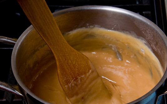 1. Этап. Крем для пропитки коржей: 5. После закипания всыпьте сахар. В небольшом количестве воды растворите соду и добавьте в кастрюлю. Убавьте огонь до минимума и, постоянно помешивая, уварите до карамельного цвета и загустения. На это уйдет не менее часа.