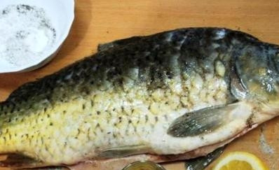 1. Этап. Карп с шампиньонами: Карпа чистим от чешуи, внутренностей и тщательно промываем водой. Выдавливаем сок лимона внутрь и снаружи рыбы, а затем натираем тушку солью, перцем и приправой для рыбы.