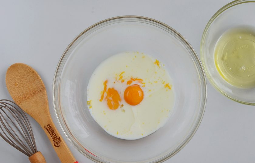 1. Этап. Сырная выпечка: Куриные яйца разделите на желтки и белки. Желтки в большой миске соедините с молоком и растительным маслом. А белки взбейте в другой миске до пышной устойчивой пены.