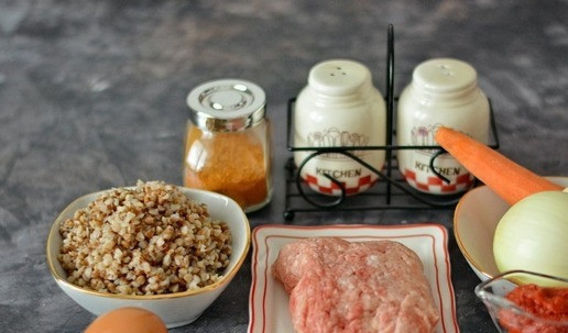 1. Этап. Гречаники в томатном соусе: Подготовьте необходимые продукты для приготовления гречаников в томатном соусе. Очистите и сполосните лук, морковь и зубчик чеснока. Гречка у вас должна быть уже отварена и остужена. Если нет готовой варёной гречневой каши, то возьмите 70-80 г сухой крупы и примерно 150-180 мл воды и сварите гречку до готовности.