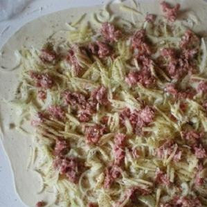 1. Этап. Узбекское блюдо Ханум: 2. Лук и картофель вымыть и почистить. Лук нарезать тонкими полукольцами. Картофель можно нарезать мелким кубиком или натереть на терке, чтобы удобно было разложить на тесте. После этого раскатать тесто в очень тонкий пласт. Смазать лист растительным маслом. Выложить на тесто лук, мясной фарш и картофель. Насыпать на начинку по вкусу соль и специи. Обычно используют кинзу и зру. Завернуть тесто с начинкой в рулет.