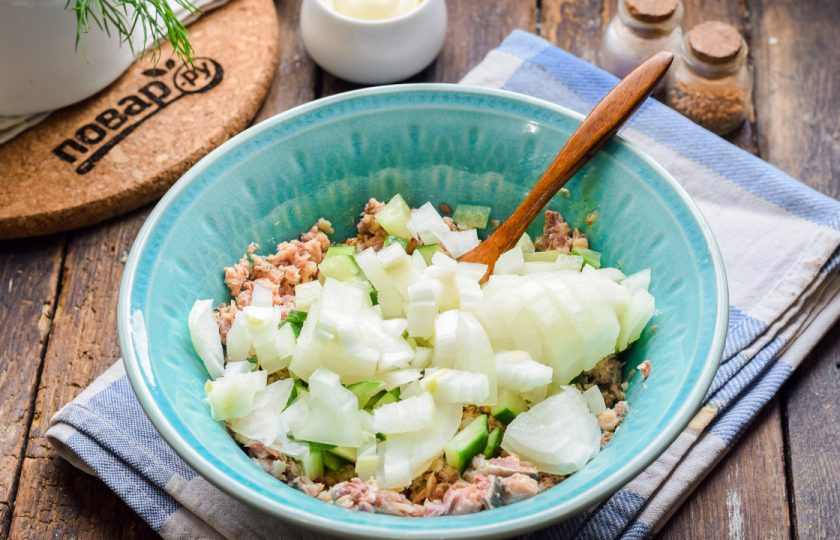 1. Этап. Салат из консервированной сайры: Репчатый лук очистите и ополосните, нарежьте мелкими кубиками. При желании лук можете замариновать в уксусе.