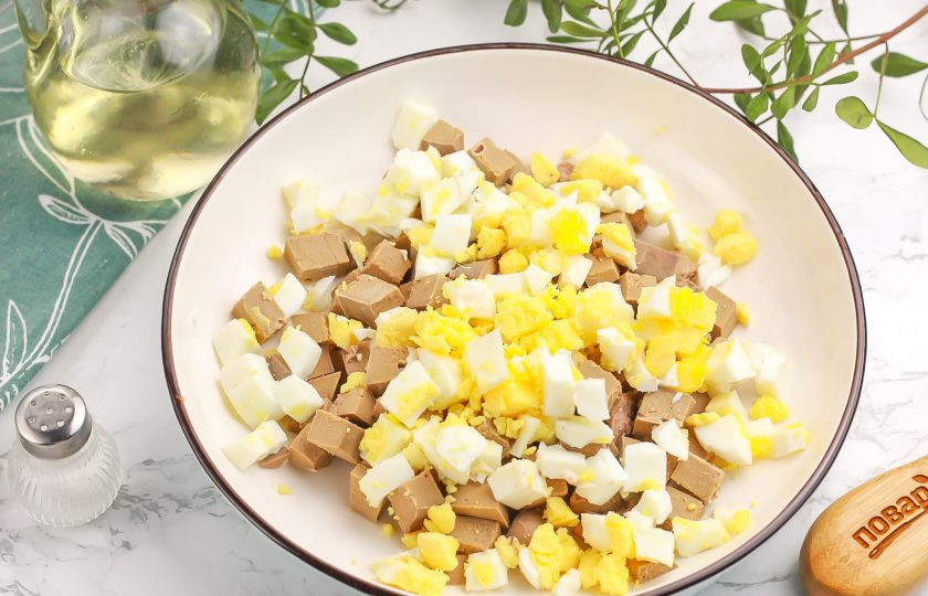 1. Этап. Салат из печени баранины: Очистите отварные куриные яйца от скорлупы и промойте в воде. Нарежьте такими же кубиками и добавьте к печени.