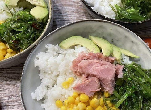 1. Этап. Поке с тунцом: На рис разложите начинку: консервированную кукурузу, филе тунца, салат из морских водорослей чука, помидоры черри, ананас консервированный и кусочки авокадо.