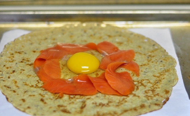 1. Этап. Ржаные блины с лососем: 3. Затем блины выложите на пергаментную бумагу на противне. В центр выложите кусочки лосося и разбейте по яйцу. Края блина сверните к центру.