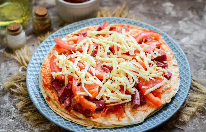 1. Этап. Пицца на сковороде за 15 минут: Засыпьте заготовку стружкой сыра. Специи добавьте на свой вкус.