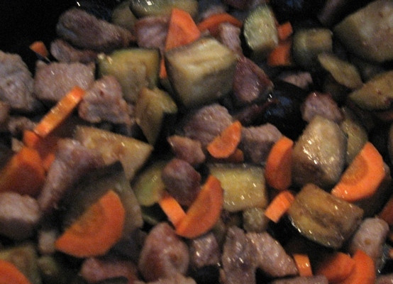 1. Этап. Баклажаны, жаренные со свининой: Чистим морковку, нарезаем и отправляем к баклажанам с мясом. Перемешиваем. Крышкой сковороду уже не закрываем.