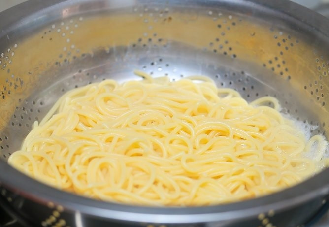 1. Этап. Вкусные спагетти: 5. Спагетти откиньте на дуршлаг, а после переложите обратно в кастрюлю.