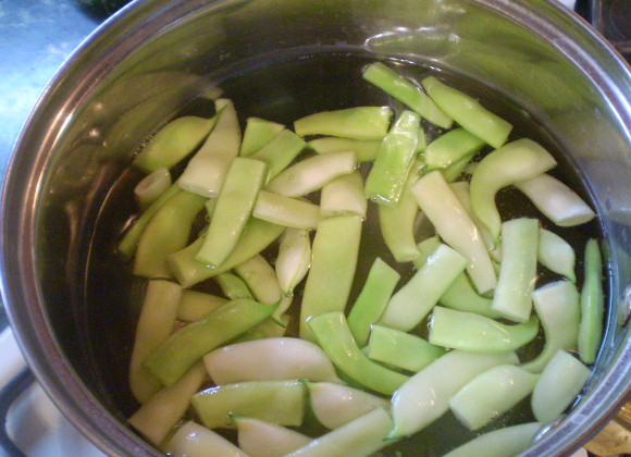 1. Этап. Салат с корейской морковью и фасолью: Порежьте фасоль небольшими кусочками. Воду посолите. Отварите фасоль до готовности (7-8 минут). Откиньте на сито, чтобы вода стекла.