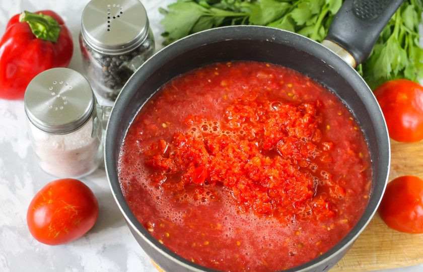 1. Этап. Заправка с перцем на зиму: Перелейте томатную массу в казан или сотейник с антипригарным дном. Выложите туда же перечную массу.