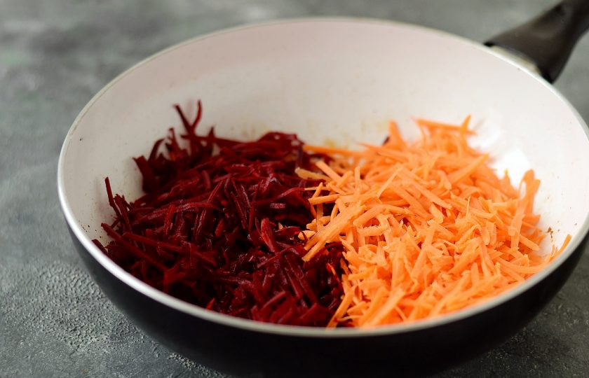 1. Этап. Борщ из савойской капусты: Добавьте томатную пасту, немного обжарьте вместе с луком. Следом добавьте мелко нашинкованную свеклу и морковь. Обжарьте пару минут, постоянно помешивая. Затем влейте воду так, чтобы она покрывала овощи, добавьте сахар и тушите овощи до полуготовности.