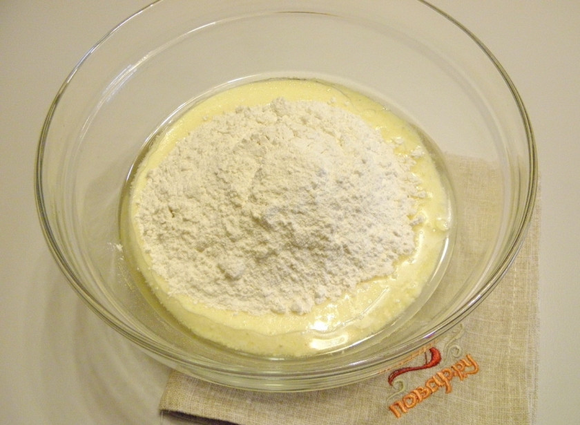 1. Этап. Заливной пирог с рыбными консервами: Добавьте муку и разрыхлитель. Перемешайте тесто венчиком или миксером до однородного состояния.