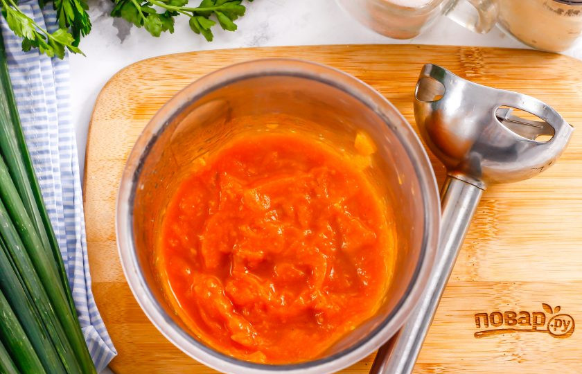 1. Этап. Кабачковая икра в микроволновке: Переместите всю массу в глубокую емкость, измельчите с помощью погружного блендера, добавив спрессованный очищенный зубчик чеснока.