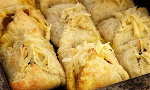 1. Этап. Слоеные пирожки с овощной начинкой: Затем пирожки отправляем в разогретую до 180 градусов духовку на 15 минут, затем достаем противень, посыпаем пирожки тертым сыром и отправляем обратно в духовку на 5 минут.