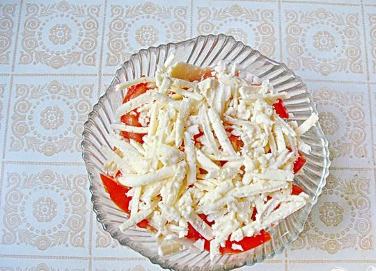 1. Этап. Закуска из кабачков Днестровская: 5. На терке натираем брынзу, хорошо, если это будет соленая козья или овечья. Должна быть брынза твердой, для того, чтобы лучше терлась. Слой тертой брынзы выкладываем сверху слоя томатов.