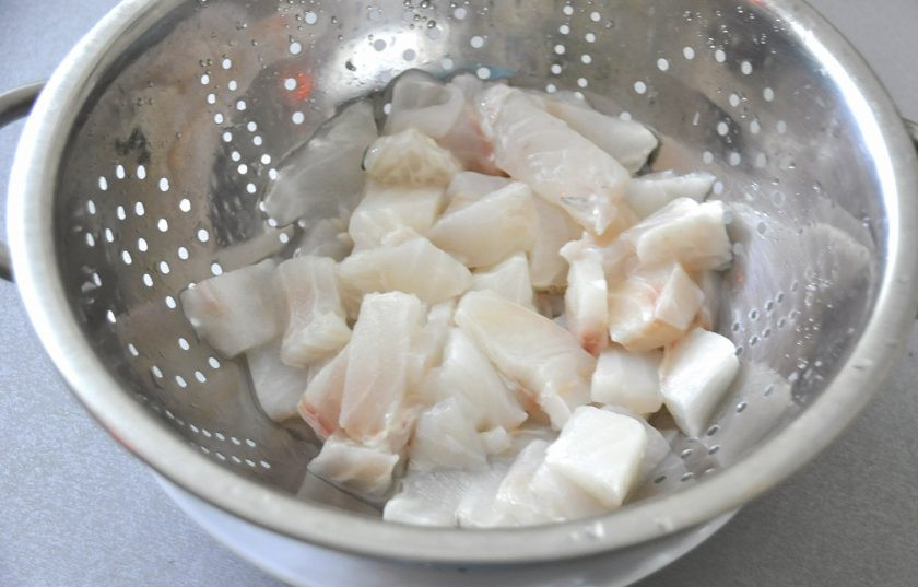 1. Этап. Пирог с зубаткой: Пока тесто находится на расстойке, займитесь начинкой для пирога. Очистите зубатку, нарежьте на кусочки и положите в дуршлаг или сито, чтобы максимально избавиться от влаги, содержащейся в рыбе в большом количестве.