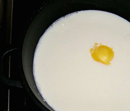 1. Этап. Бурфи из цельного молока: Для этого десерта нам понадобится кастрюля с толстым дном. Лучше, чтобы она была чугунной, поскольку от этого зависит качество бурфи. Наливаем в кастрюлю 2 литра молока, кладем ложку сливочного, либо топленого масла. Насыпаем сахар. Ставим на огонь.