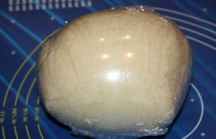 1. Этап. Тесто на круассаны: Заверните тесто неплотно в пищевую пленку и отправьте в холодильник на 5 часов. За это время тесто слегка увеличится в объеме.