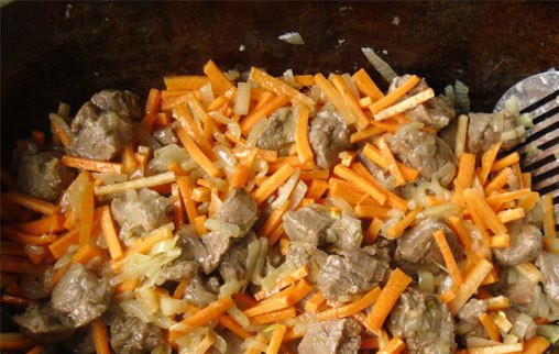 1. Этап. Плов из баранины на костре: 2. Когда мясо покроется корочкой, - добавим сначала лук (перемешаем), и спустя несколько минут, - и морковку соломкой.