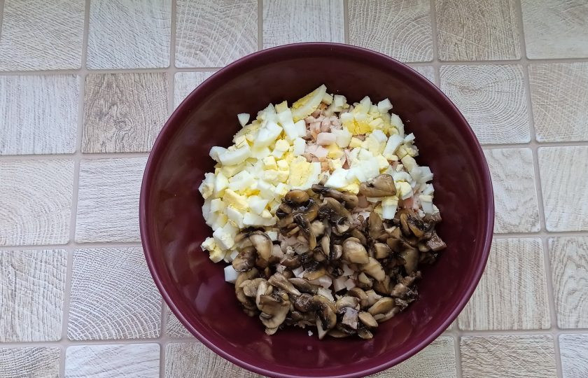 1. Этап. Салат Любимый с курицей и грибами: Шампиньоны очистите, нарежьте мелко и обжарьте на сковороде с подсолнечным маслом. Выложите в миску.