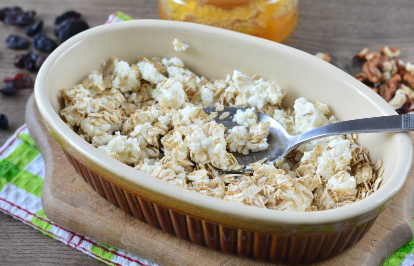 1. Этап. Гранола с творогом: Смажьте форму для выпекания маслом, выложите овсяные хлопья и творог, немного перемешайте.