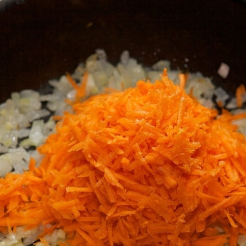 1. Этап. Лазанья с мясом: Морковь натираем на терке и добавляем к луку и чесноку. Перемешиваем и готовим на умеренном огне еще 7-10 минут.