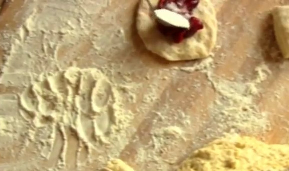 1. Этап. Жареные пирожки с вишней на кефире: 5. Вишню очистите от косточек. Каждую лепешку из теста приплюсните пальцами, в центр положите вишню и чайную ложку сахара. Аккуратно соедините края так, чтобы получился пирожок.