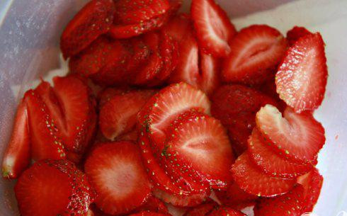 1. Этап. Клубничные пирожные: 1. Разогреть духовку до 175 градусов. Смазать форму для выпечки растопленным сливочным маслом. Выстелить форму алюминиевой фольгой или пергаментной, формируя 5-сантиметровый навес по краям. Нарезать клубнику на ломтики и посыпать 1 чайной ложкой сахара, перемешать, накрыть крышкой и поставить в холодильник до необходимости.