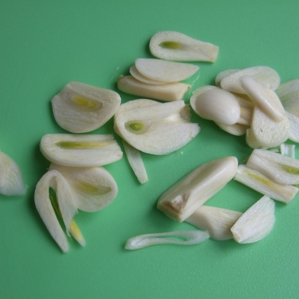 1. Этап. Свинина в духовке: Тонкими пластинами нарезаем чеснок.