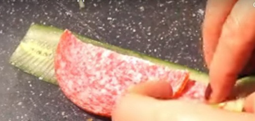 1. Этап. Закуска на праздничный стол: Огурец с помощью овощерезки нарезаю на слайсы, на каждом слайсе с помощью ножа делаю тонкие и мелкие надрезы, на огурец кладу три кусочка салями и сворачиваю в рулет.