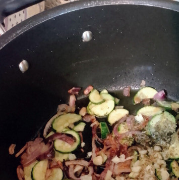 1. Этап. Рис с цуккини под арахисовым йогуртом: Вскипятить бульон. Затем уменьшить огонь и томить рис в бульоне 10 минут до готовности. Тем временем, на дне глубокого казана на среднем огне разогреть 3 столовых ложки оливкового масла, добавить 1 чайную ложку соли и жарить красный лук 8 минут до размягчения. Затем добавить цуккини, готовить 15 минут. И наконец, всыпать чеснок, 1 чайную ложку кориандра, черный перец по вкусу и зиру. Продолжать готовить ещё 2 минуты до появления аромата. .