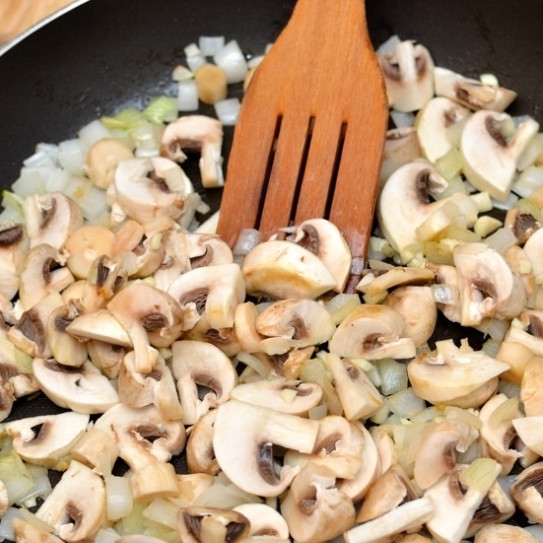 1. Этап. Яичница-болтунья с грибами: В сковороде разогреваем оливковое масло, выкладываем в него шампиньоны, лук и чеснок. Обжариваем 3-4 минуты на среднем огне.